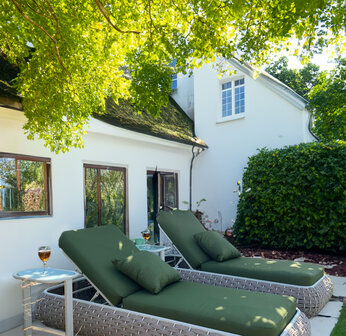 Ligbeddenset bruin wicker olijfgroene kussens zijaanzicht tuin